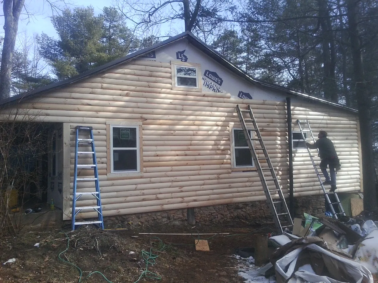 Ladders set against fresh log siding during an exterior remodel in Aberdeen